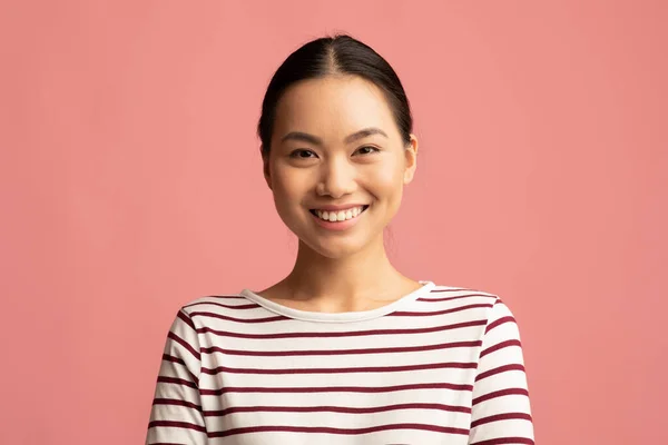 Retrato de positivo atraente jovem asiático mulher posando sobre fundo rosa — Fotografia de Stock