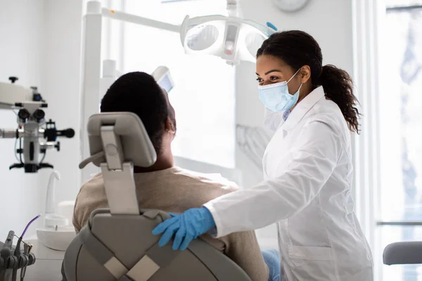 Retrato de mulher dentista negra e reunião de paciente masculino na clínica estomatológica — Fotografia de Stock