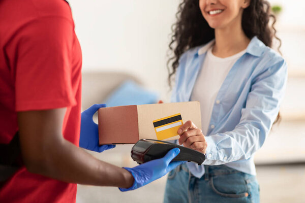 Portrait of black man holding POS machine for payment