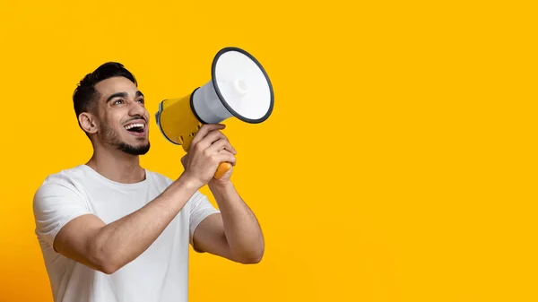 Tipo árabe excitado hablando alto, usando megáfono en amarillo — Foto de Stock