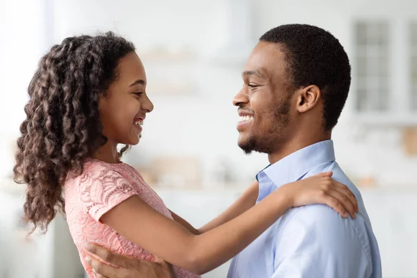 Menina negra e pai abraçando, olhando um para o outro — Fotografia de Stock