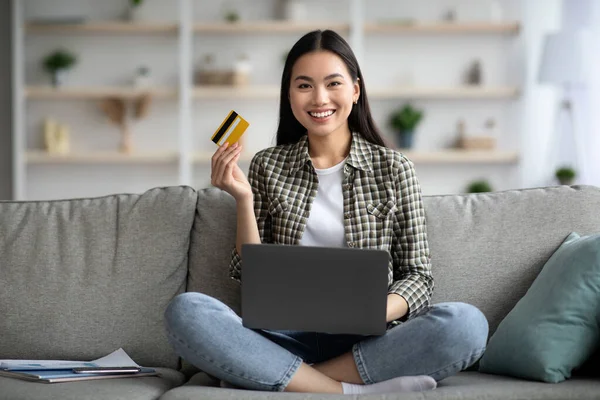 Mujer feliz usando portátil y tarjeta de crédito en casa — Foto de Stock
