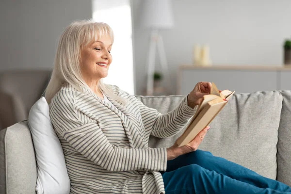 Idős nő, aki otthon pihen, olvasókönyv — Stock Fotó