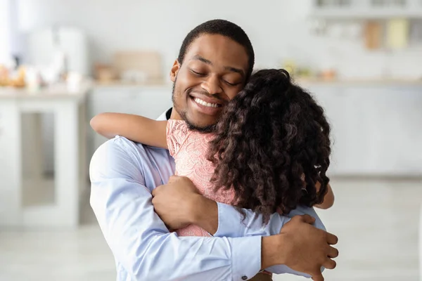 Amoroso pai negro e filha abraçando com os olhos fechados — Fotografia de Stock