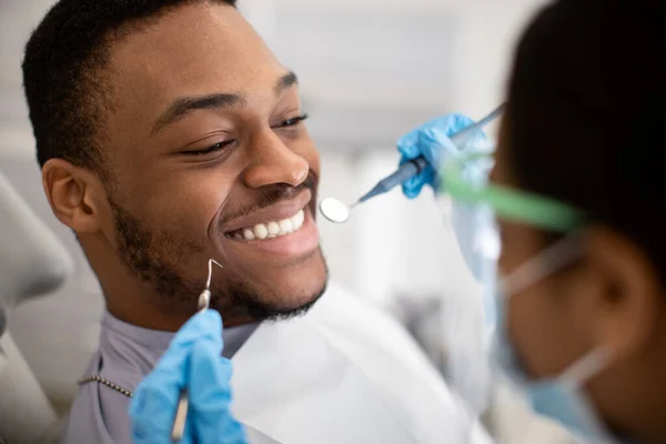 Bonito sorriso preto homem sentado na cadeira de dentista pronto para check-up — Fotografia de Stock