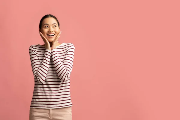 Verrast aziatische vrouw aanraken gezicht en kijken naar kopiëren ruimte met opwinding — Stockfoto