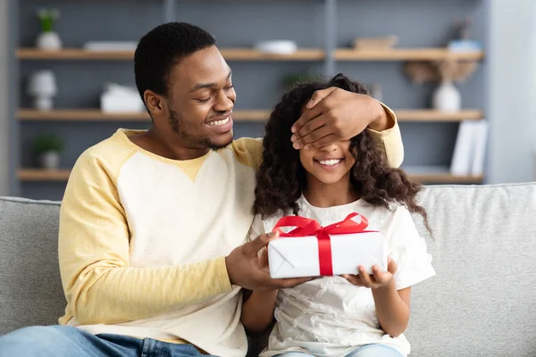 Sevgi dolu siyah baba tatlı kızına hediye veriyor.