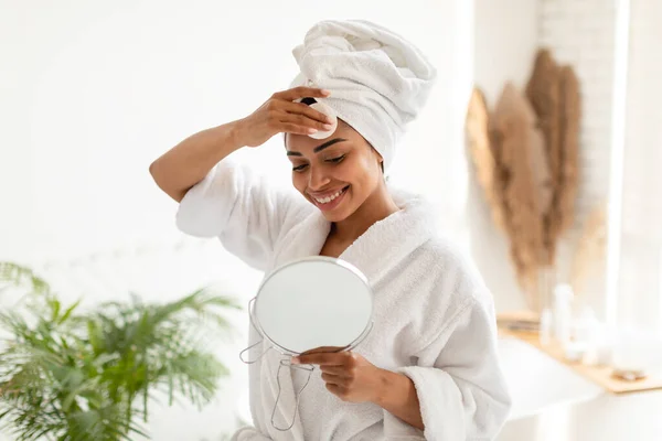 Dame noire démaquillant avec coton tampon dans la salle de bain — Photo