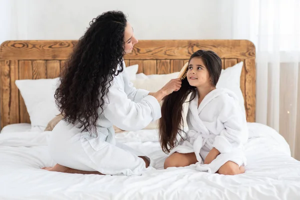 Amare la mamma pettinando i capelli della figlia e raccontando storie — Foto Stock