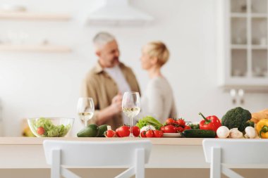Mutlu bir çift, modern mutfakta romantik bir dans, gülümseyen karı koca yıldönümlerini kutluyor.