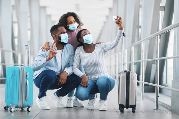 Feliz familia negra viajando con un niño, tomando selfie en el aeropuerto — Foto de Stock
