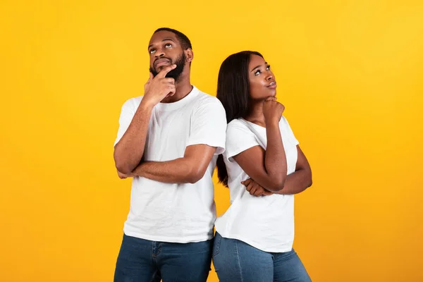 Negro hombre y mujer pensando en el fondo amarillo — Foto de Stock