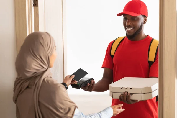 Schwarzer Zusteller mit Pizzaschachtel und POS-Terminal — Stockfoto