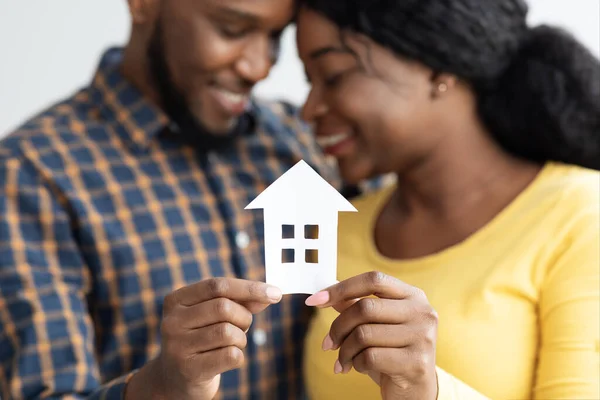 African American Spouses Holding Cutout Paper House Figure In Hands