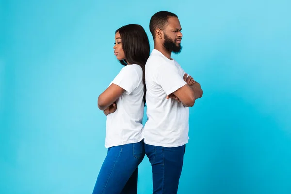 一对黑人夫妇背靠背站着，蓝色的工作室墙壁 — 图库照片