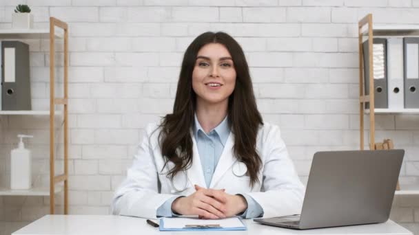 Uśmiechnięta terapeutka rozmawiająca Siedząc na laptopie w biurze — Wideo stockowe