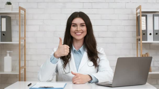 Medico femminile gesturing pollice fino in posa sul posto di lavoro al coperto — Video Stock