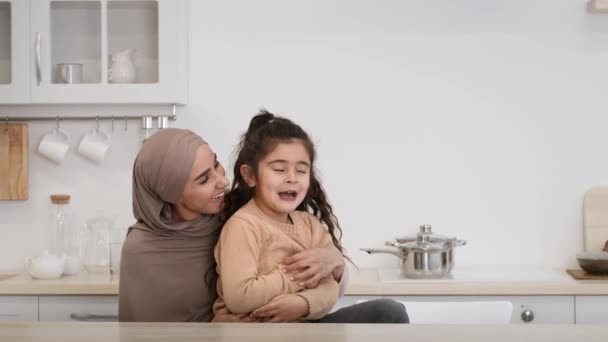 快乐的穆斯林母亲在厨房里爱抚和拥抱小女儿 — 图库视频影像
