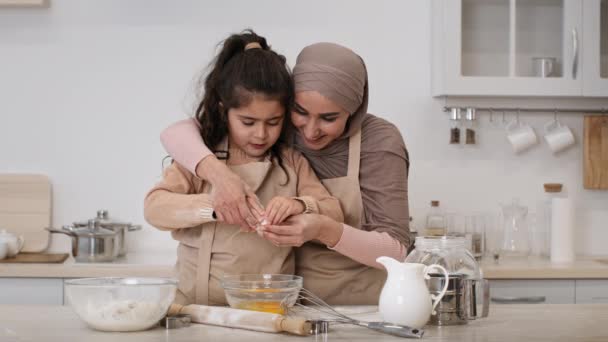 Alegre musulmán mamá y poco hija hacer masa en cocina — Vídeos de Stock
