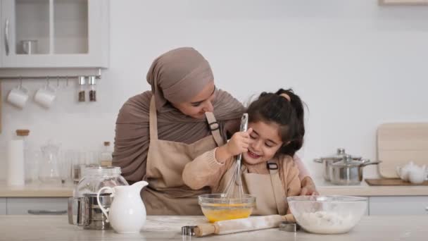 Mère dans hijab et fille cuisson faire la pâte dans la cuisine — Video