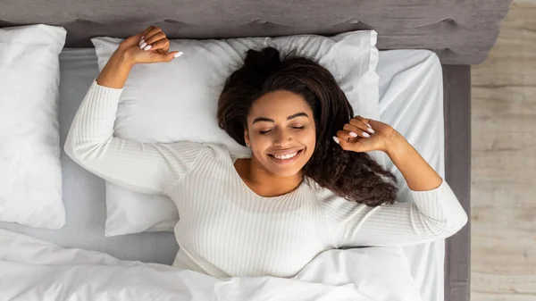 Happy young African American female stretching after waking up — Stock Photo, Image