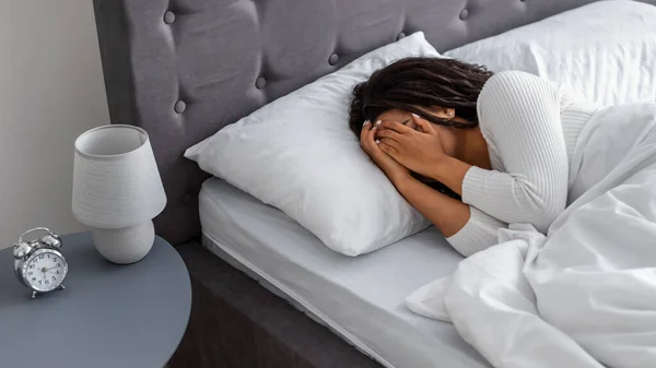 Μαύρη γυναίκα κλαίει, ξαπλωμένη στο κρεβάτι σκεπασμένη στο πρόσωπο — Φωτογραφία Αρχείου
