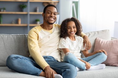 Sevimli siyah aile babası ve kızı birlikte film izliyorlar.