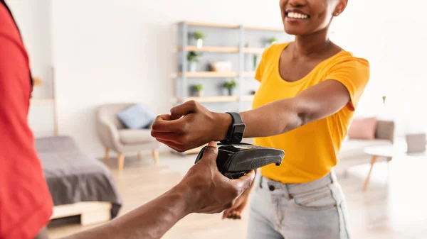 Kurier gibt Terminal an Kunden, die zu Hause mit Smartwatch bezahlen — Stockfoto