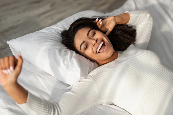 Happy African American lady stretching after waking up — Stock Photo, Image