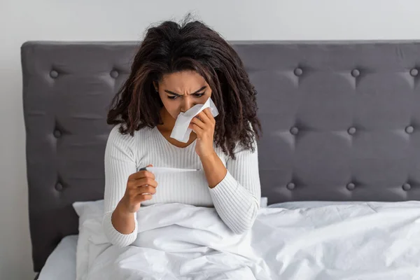 Black woman with rinny nose checking body temperature — Stock Photo, Image