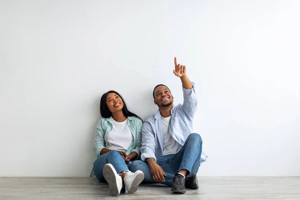 Soñando pareja afroamericana planificación de interiores, decoraciones y muebles en su propia casa, espacio vacío — Foto de Stock