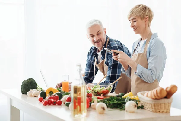 Senior par spela in video om vegetarisk mat på kameran i köket — Stockfoto
