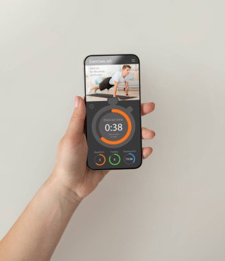 Cep telefonunda fitness uygulaması kullanan kadın