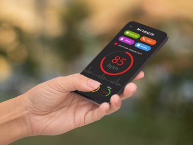 Ekranda sağlık kitabı uygulaması olan akıllı telefon kullanan bir kadın.