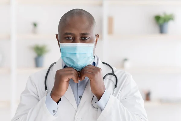 Médico americano africano confiante usando máscara cirúrgica médica para prevenir infecção, doença, gripe ou covid-19 — Fotografia de Stock