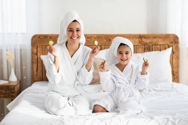 Sorridente mamma e bambina mostrando cerchi di cetriolo — Foto Stock