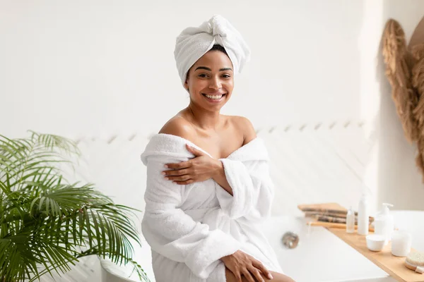 Bastante negro hembra posando sentado en bañera en cuarto de baño — Foto de Stock