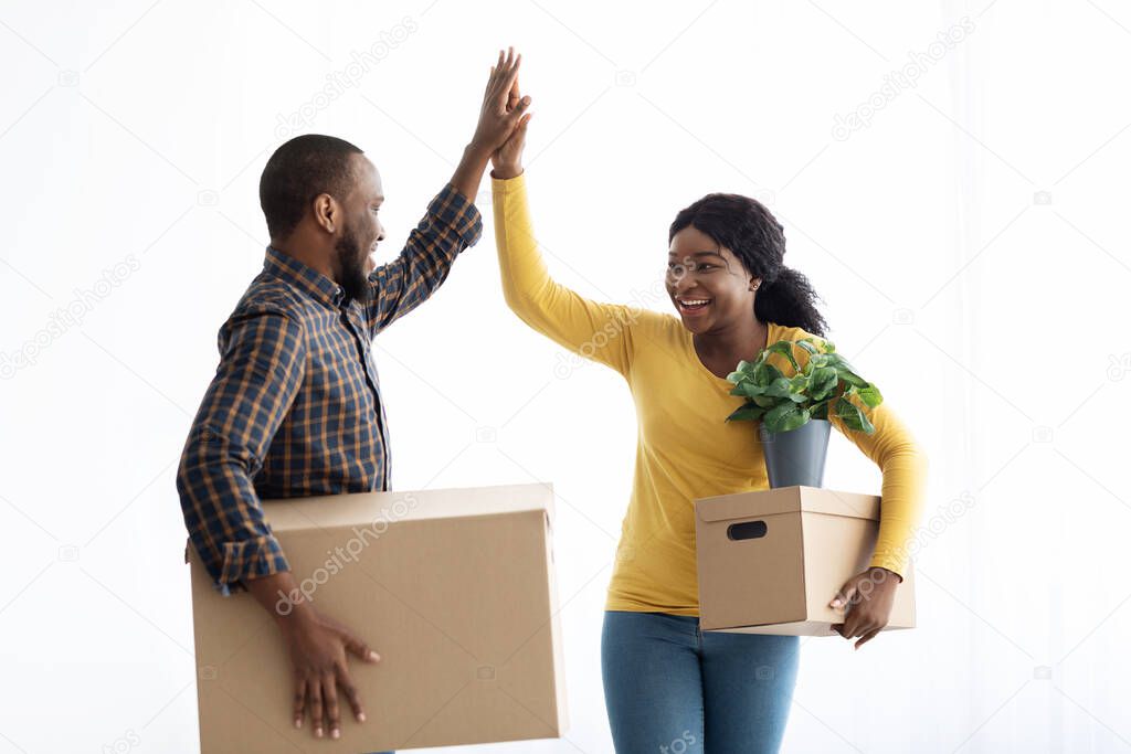 Happy Young Black Couple Giving High Five, Celebrating Moving To New House