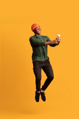 Neşeli Afrikalı Amerikalı Adam Havada Zıplarken Modern Akıllı Telefon Kullanıyor