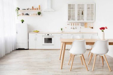 İskandinav tarzında minimalist mutfak tasarımı. Laleli yemek masası, çatal bıçaklı mobilya, boş yer.
