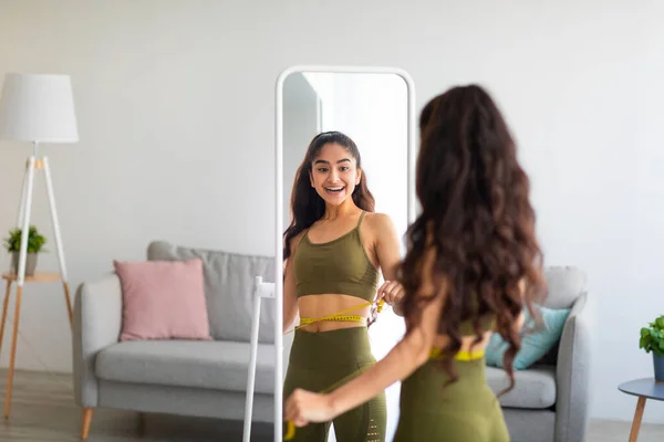 Portrait de femme indienne mince mesurant sa taille devant le miroir à la maison, espace libre. Concept de saine alimentation — Photo