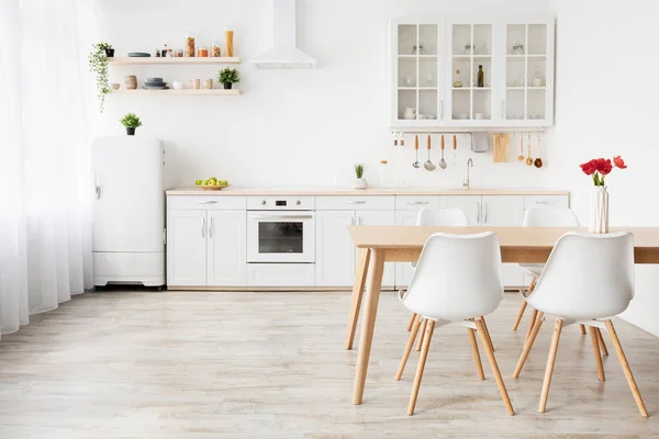 Design minimaliste de cuisine dans un style scandinave. Table à manger avec tulipes et meubles avec ustensiles, espace vide — Photo
