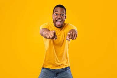 Duygusal Siyahi Adam Sarı Arkaplan Üzerindeki Kamerayı İşaret Ediyor