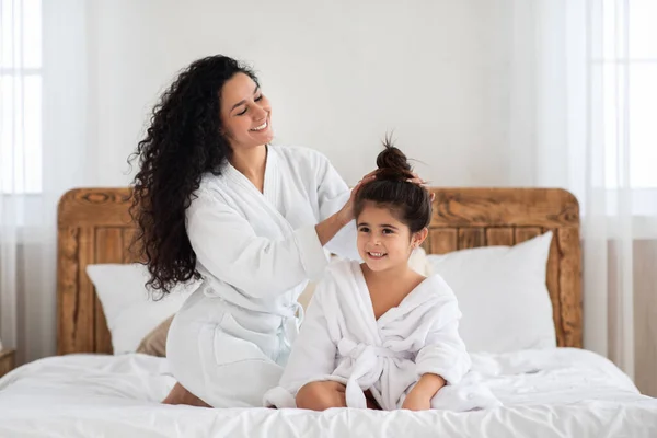 Bela mãe de cabelos claros penteando seu cabelo filha — Fotografia de Stock