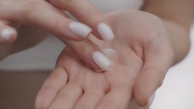 Doğal vücut bakımı kozmetikleri. Kadın ellerini nemlendirici kremle kapat, kadın parmaklarıyla losyona dokunsun.