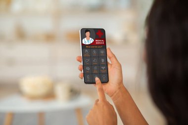 Afrika kökenli Amerikalı kadın cep telefonunda tıbbi servis kullanıyor.
