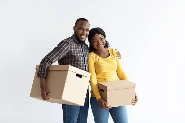 Концепция упаковки. Портрет счастливой черной пары, держащей в руках картонные коробки — стоковое фото