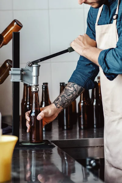 Jovem trabalha na fábrica de cerveja. Cervejeiro com equipamento industrial na cervejaria — Fotografia de Stock