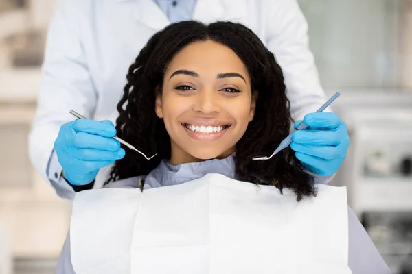 Πορτρέτο της χαρούμενης νεαρής μαύρης γυναίκας έχοντας check up στην οδοντιατρική κλινική — Φωτογραφία Αρχείου