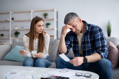 Ciddi, olgun bir adam ve karısı aile bütçesini ya da vergilerini hesaplıyor, faturaları ve harcamaları kontrol ediyor, evde borçları var.